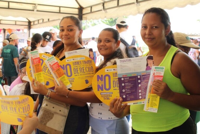 Mujeres con folletos sobre la prevención de violencia de género.