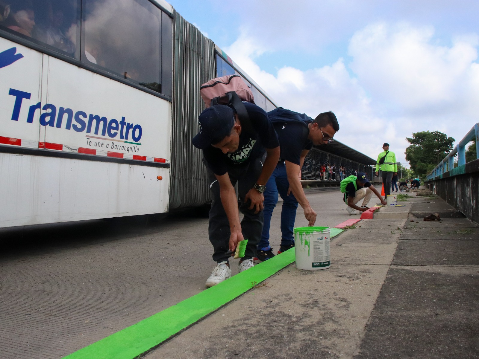 Joven pinta bordillo aledaño a la estación de Transmetro. 