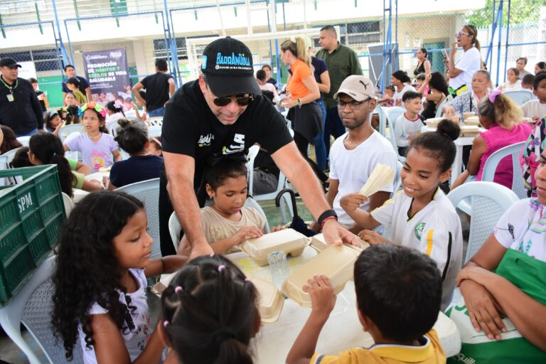 Alcalde Char entregando almuerzo a niños en comedor comunitario.