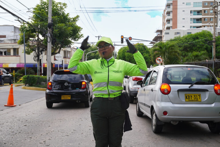 Regulador de transito indicando a los vehiculos por donde transitar