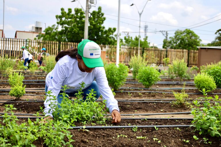 Mujer atendiendo plantas en el jardín del Parque Productivo Las Gardenias.