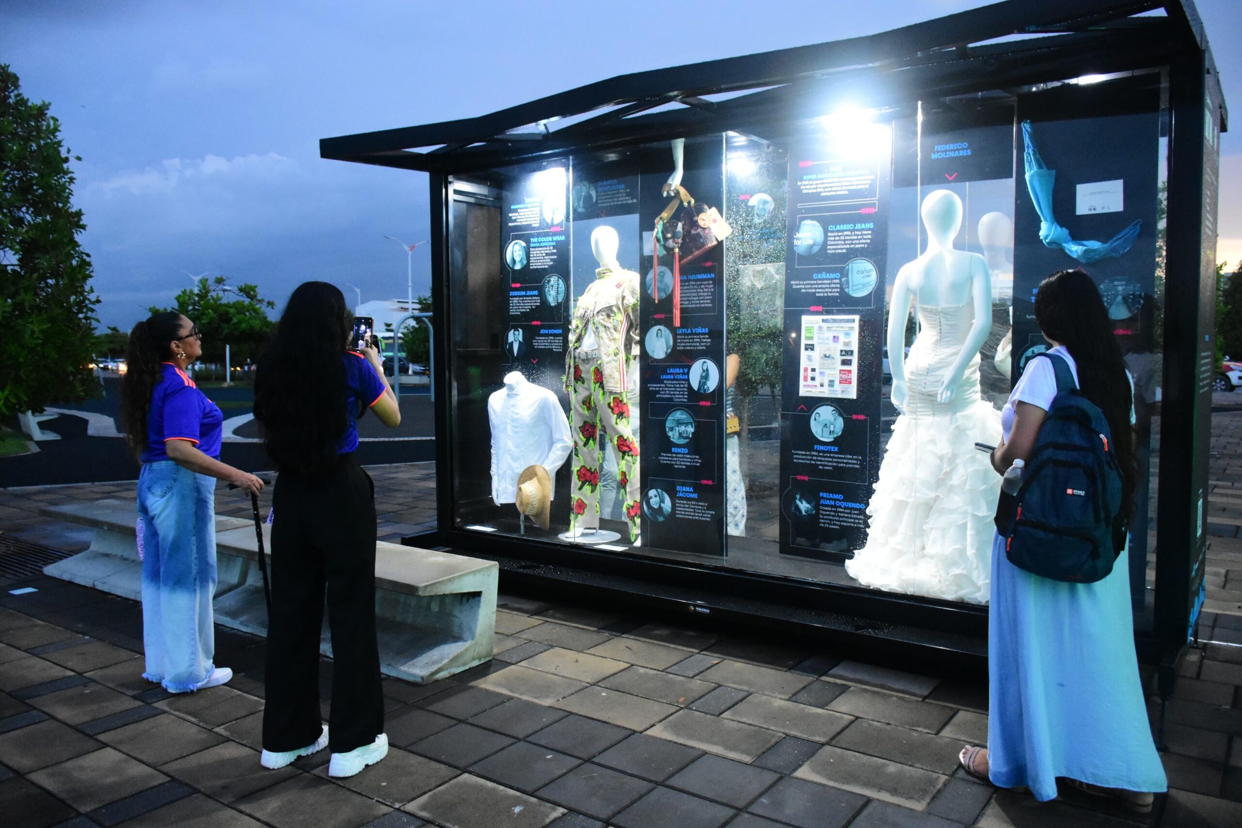 Grupo de personas observando un exhibidor de vestidos en Barranquilla es Moda, un museo a cielo abierto.