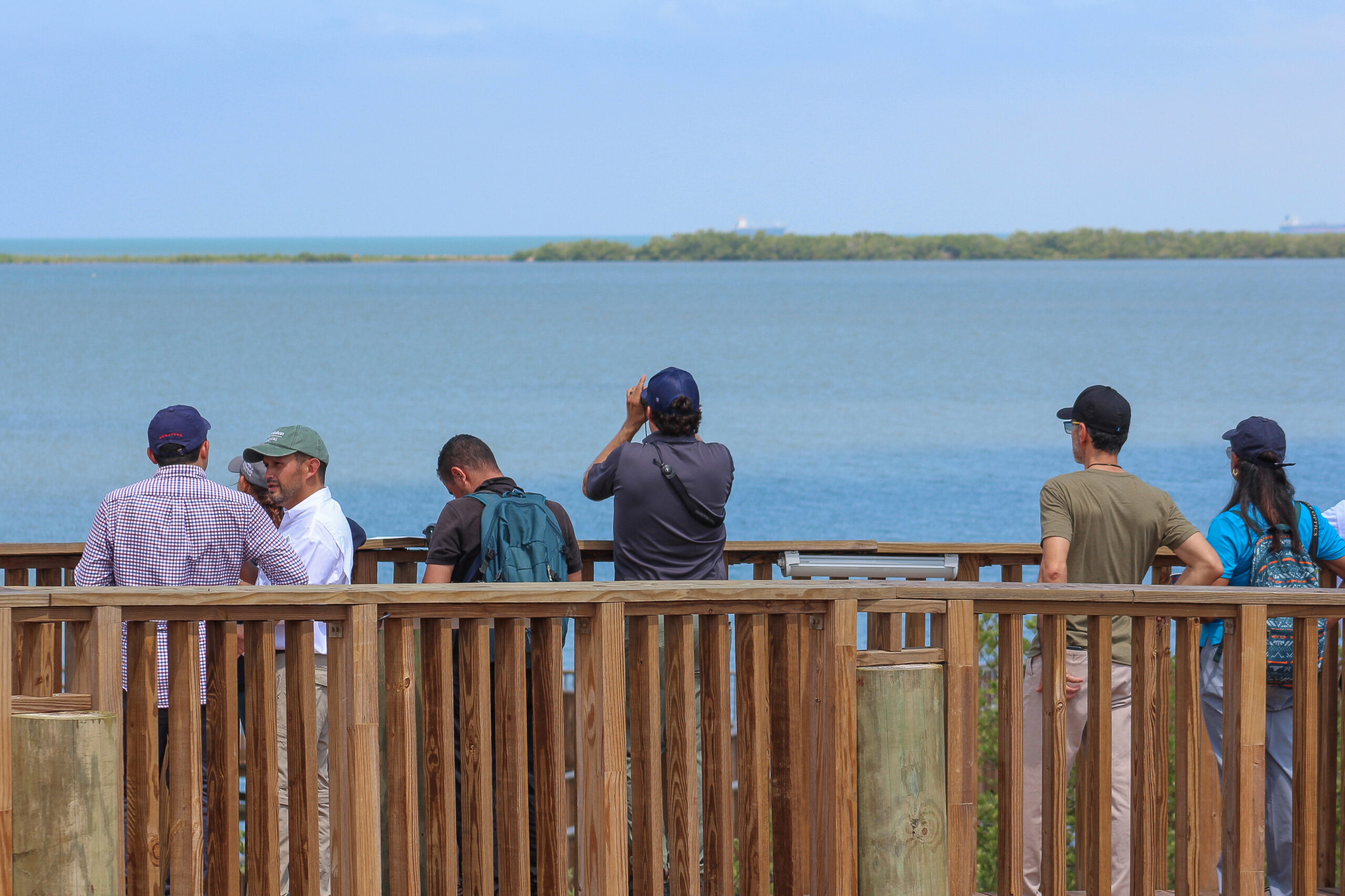 Grupo de personas en una barandilla, observando aves en la Ciénaga de Mallorquín