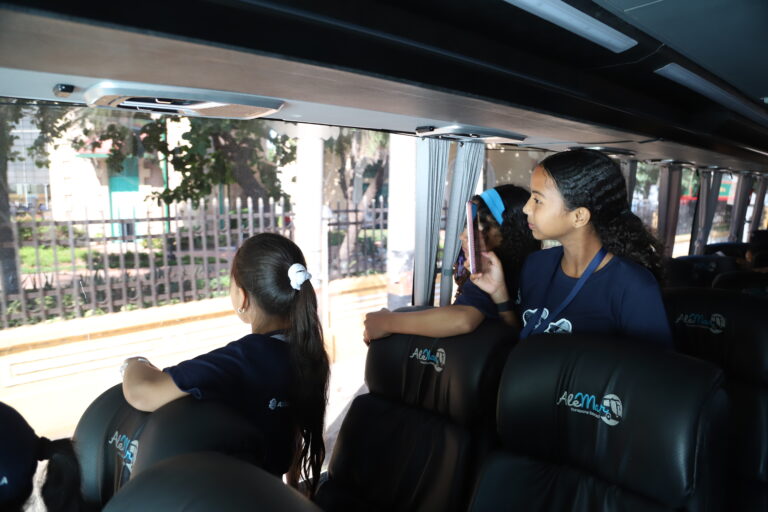 Niños y niñas del diplomado observan la ciudad desde el bus en su recorrido.