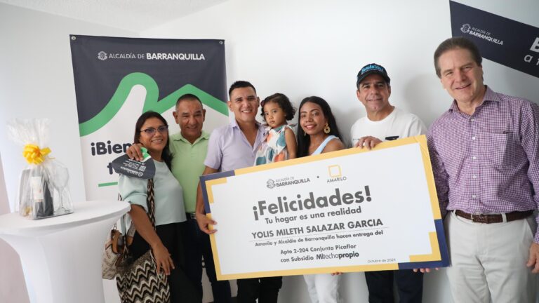 Alcalde Char, junto a grupo de personas, entrega cheque simbólico a beneficiario de Mi Techo Propio