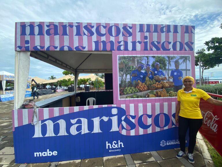 Cocinera de tradición junto a un stand de mariscos.