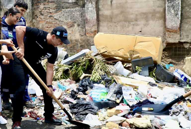 Alcalde Char recoge basura con una pala durante una actividad de limpieza.