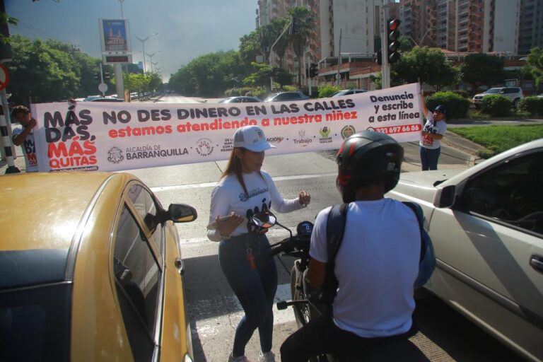 Funcionarios en campaña de sensibilización con pasacalles en calles, entregando volantes a conductores