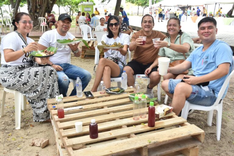 Grupo de asistentes disfrutando una variedad de platos típicos en Sabor Bajero.