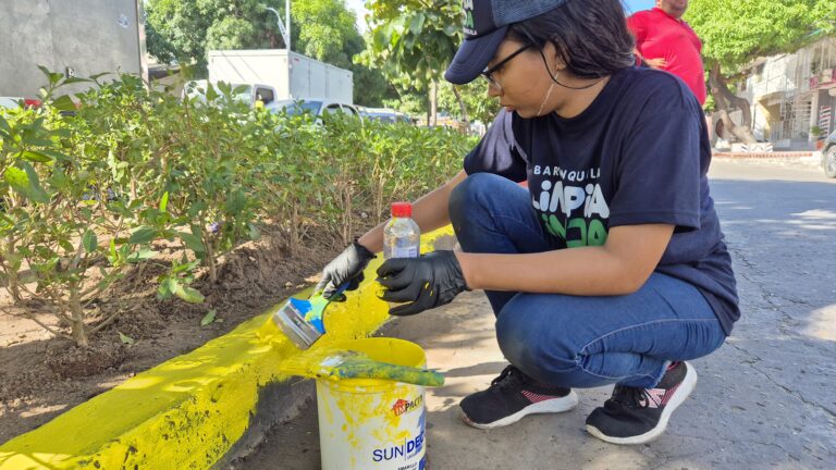 Voluntaria de Barranquilla Limpia y Linda pintando anden.