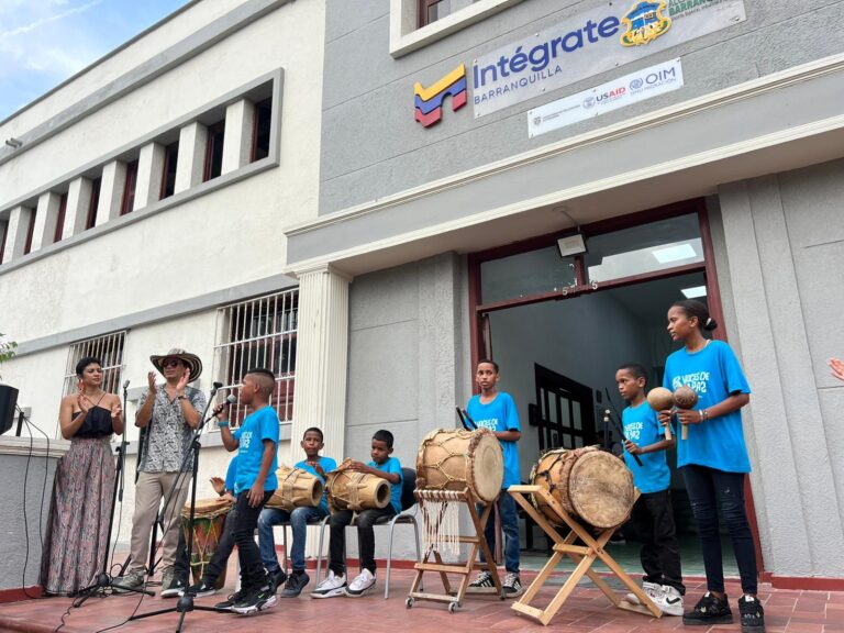 Niños en las afueras del Centro Intégrate en presentación musical.