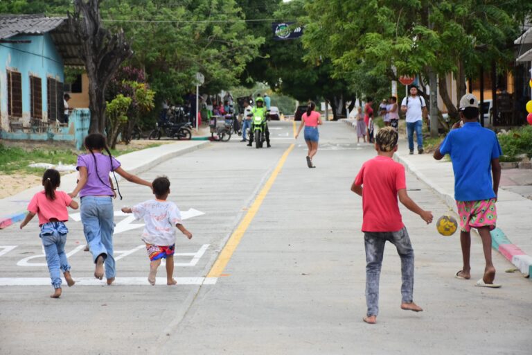 Niños jugando en una nueva calle pavimentada del programa Barrios a la Obra.