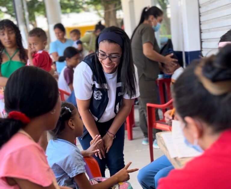 Stephanie Araujo conversando con las niñas durante una brigada de salud.