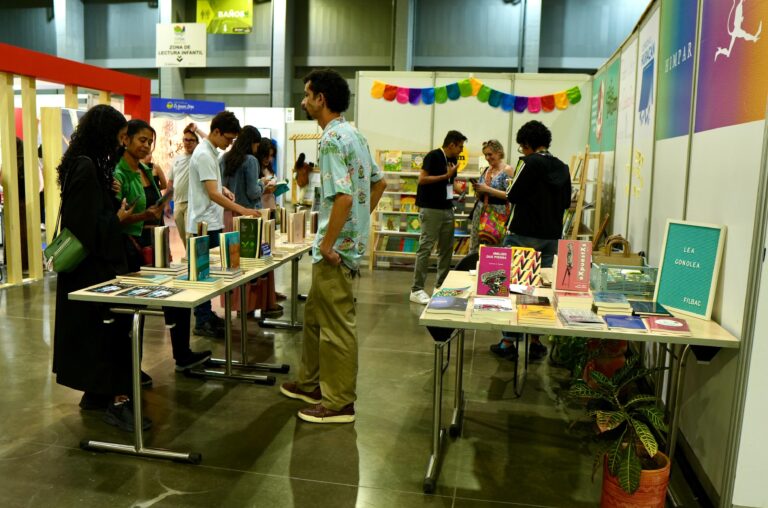 Asistentes viendo libros en mesas exhibidos durante la Feria Internacional del Libro.