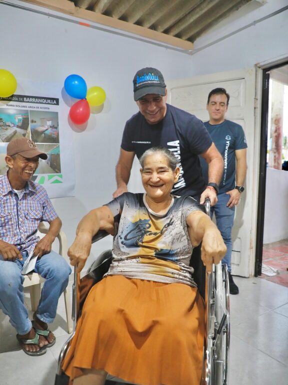 Alcalde Char acompañado de ciudadana en silla de ruedas sonriendo en entorno amigable.