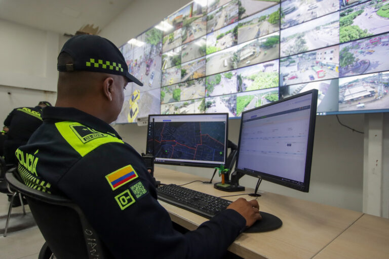 Oficial de policía frente a pantalla supervisando videovigilancia en tiempo real.