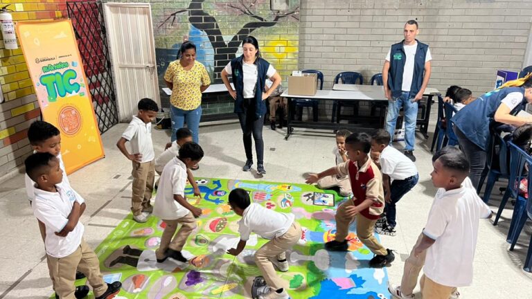 Funcionarios y niños en dinámica en aula de clases.