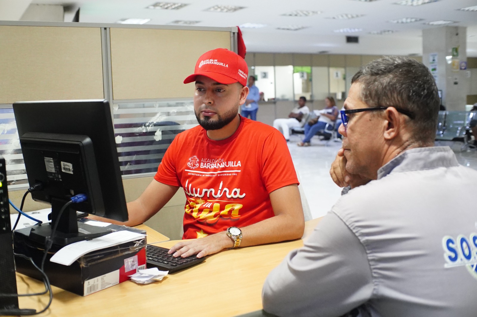 Funcionario atendiendo a usuario en la secretaria de transito