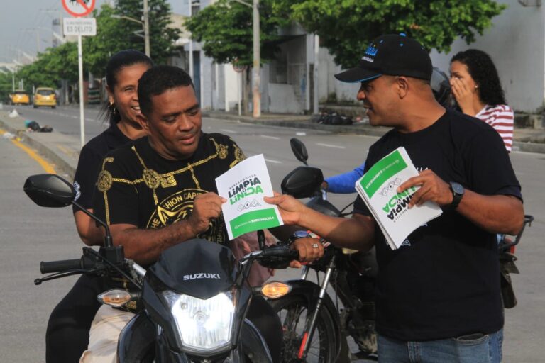 Voluntarios de Barranquilla Limpia y Linda entregando folletos de sensibilización a ciudadanos.