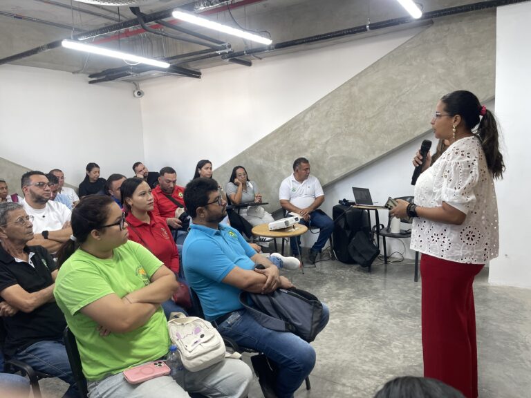 Grupo de recicladores en auditorio en mesa de trabajo.