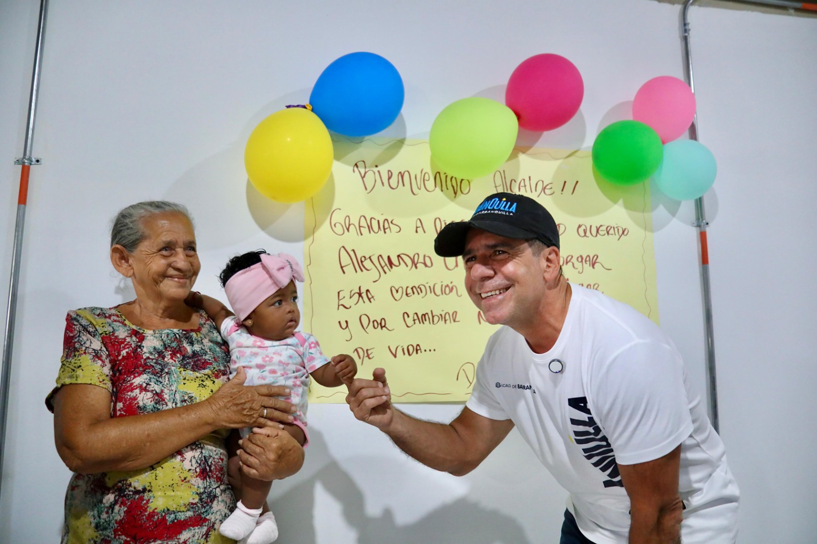 Alcalde Char junto a beneficiaria del programa de viviendas, sosteniendo a su bebé.