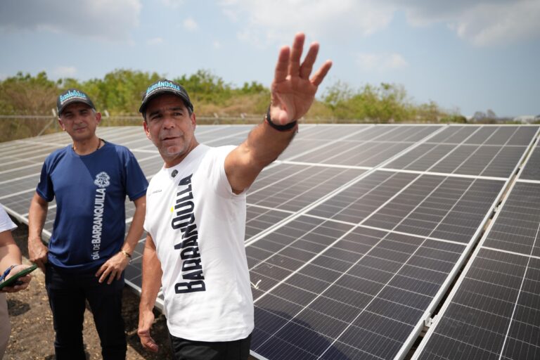 El alcalde Char, acompañado de un funcionario, posa señalando los paneles solares.