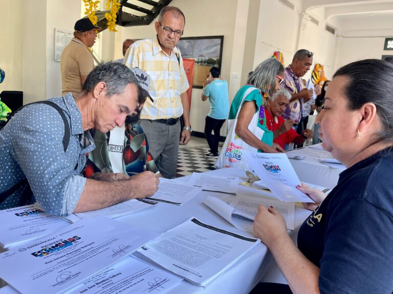 Beneficiario del portafolio de estímulos firmando documento.