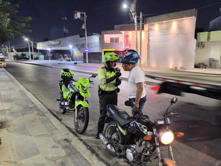 Agente de tránsito realiza prueba de alcoholemia a conductor de motocicleta.