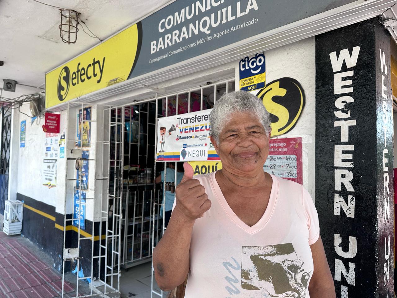 Mujer de la tercera edad frente a un establecimiento de Efecty para reclamar el Subsidio Distrital.