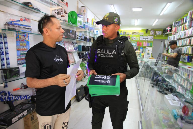 GAULA entrega volantes a comerciante en campaña contra la extorsión en Barranquilla.