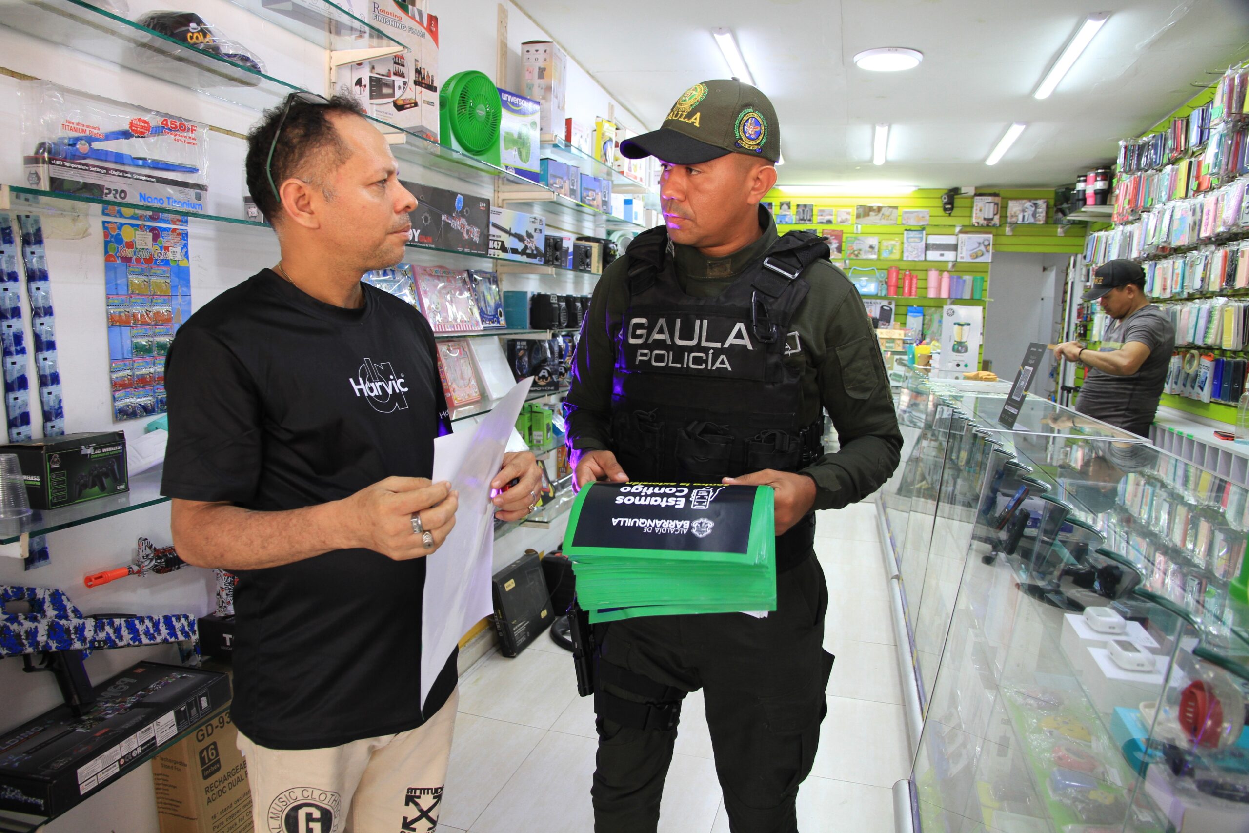 GAULA entrega volantes a comerciante en campaña contra la extorsión en Barranquilla.