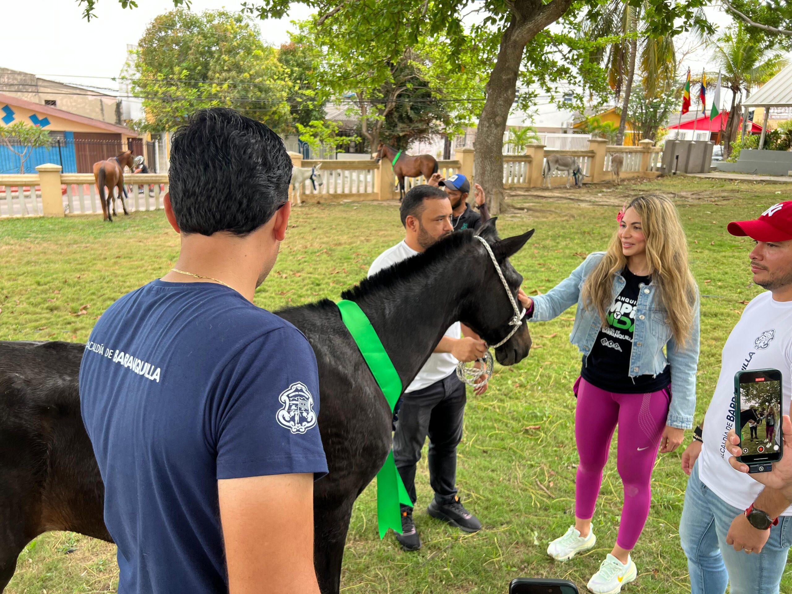 Ana María Aljure acaricia un caballo en un refugio, acompañada por funcionarios que apoyan la jornada de bienestar animal.