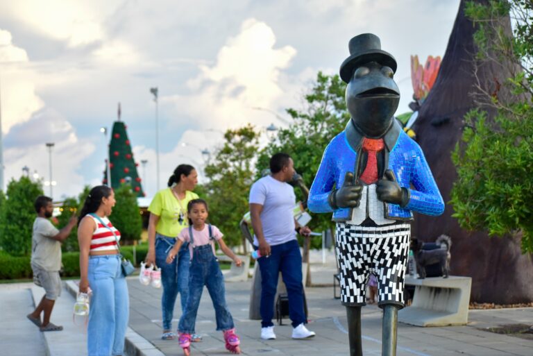 Escultura de Rinrín junto a visitantes en paseo peatonal del Gran Malecón.
