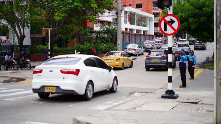 Agentes de tránsito orientan vehículos y motociclistas en intersección vial de Barranquilla.