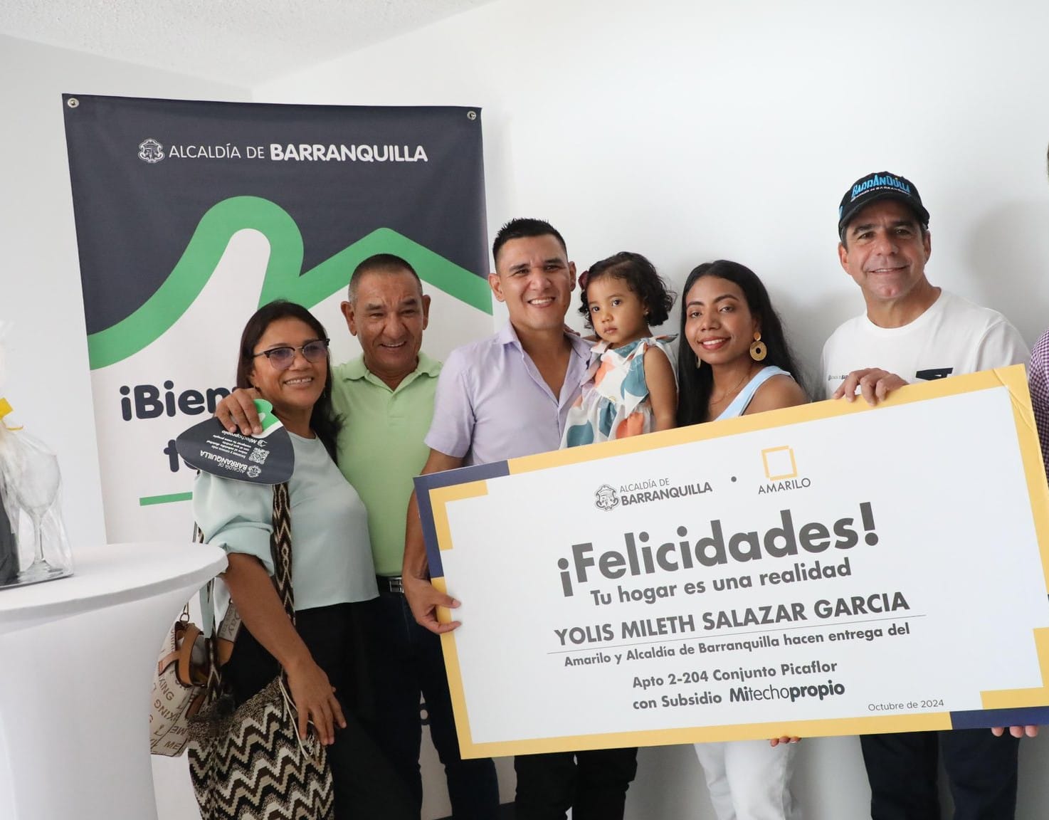 El alcalde Char, junto a beneficiarios del programa Mi Techo Propio, sostiene un cheque simbólico.