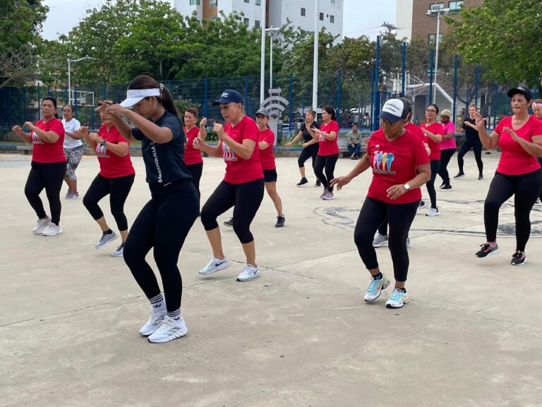 Grupo de mujeres participa en clase de baile aeróbico en parque como parte del programa 'Muévete a Otro Nivel'.