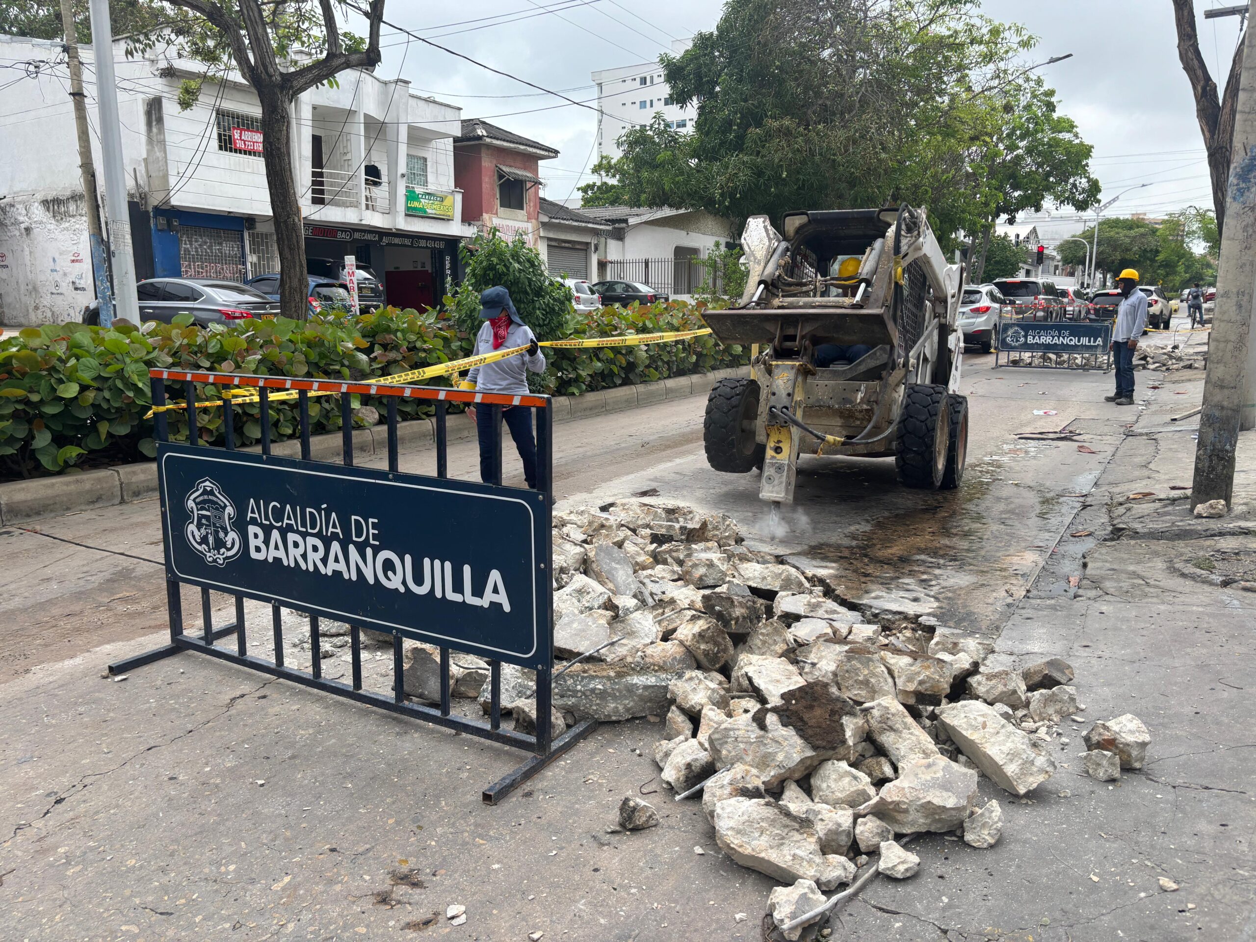 Una cuadrilla de trabajadores realiza labores de reparación vial en calle de Barranquilla.