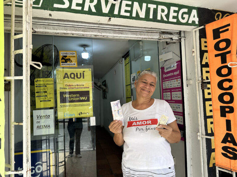 Adulta mayor frente a Servientrega sonríe con su subsidio