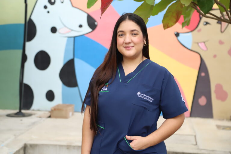 María Guevara, médica veterinaria posando sonriente en primer plano.