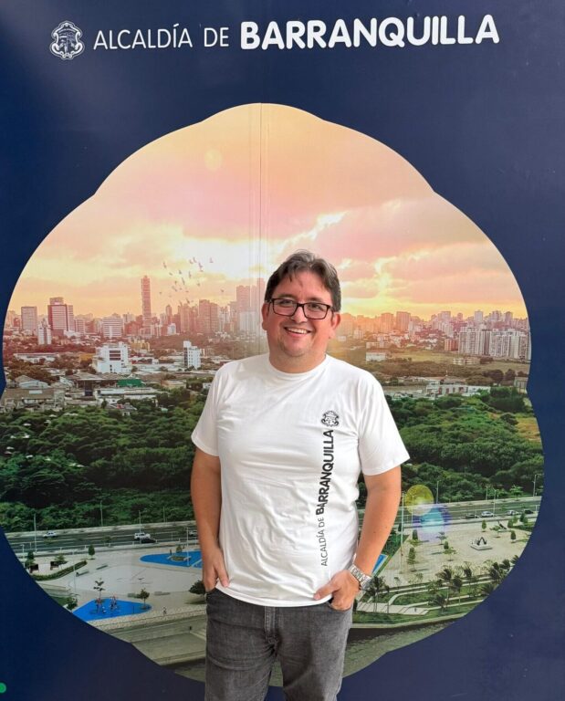 Funcionario, Henry Molina, posa con camiseta institucional blanca en plano general.general