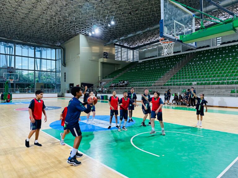 Grupo de jóvenes jugando baloncesto en una cancha cubierta de las Escuelas de Formación Distrital.