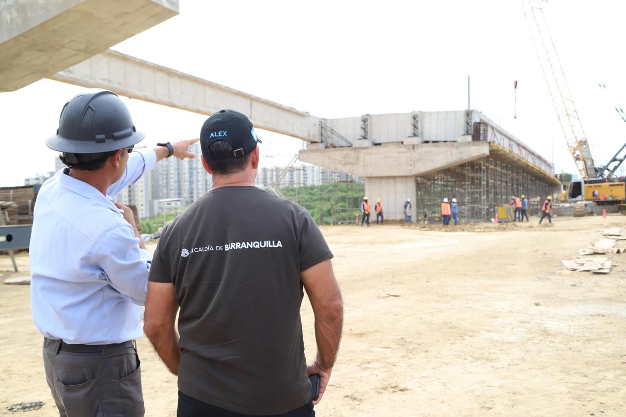 El alcalde Alejandro Char inspecciona obras del intercambiador vial, acompañado de ingeniero que señala avances de la infraestructura.