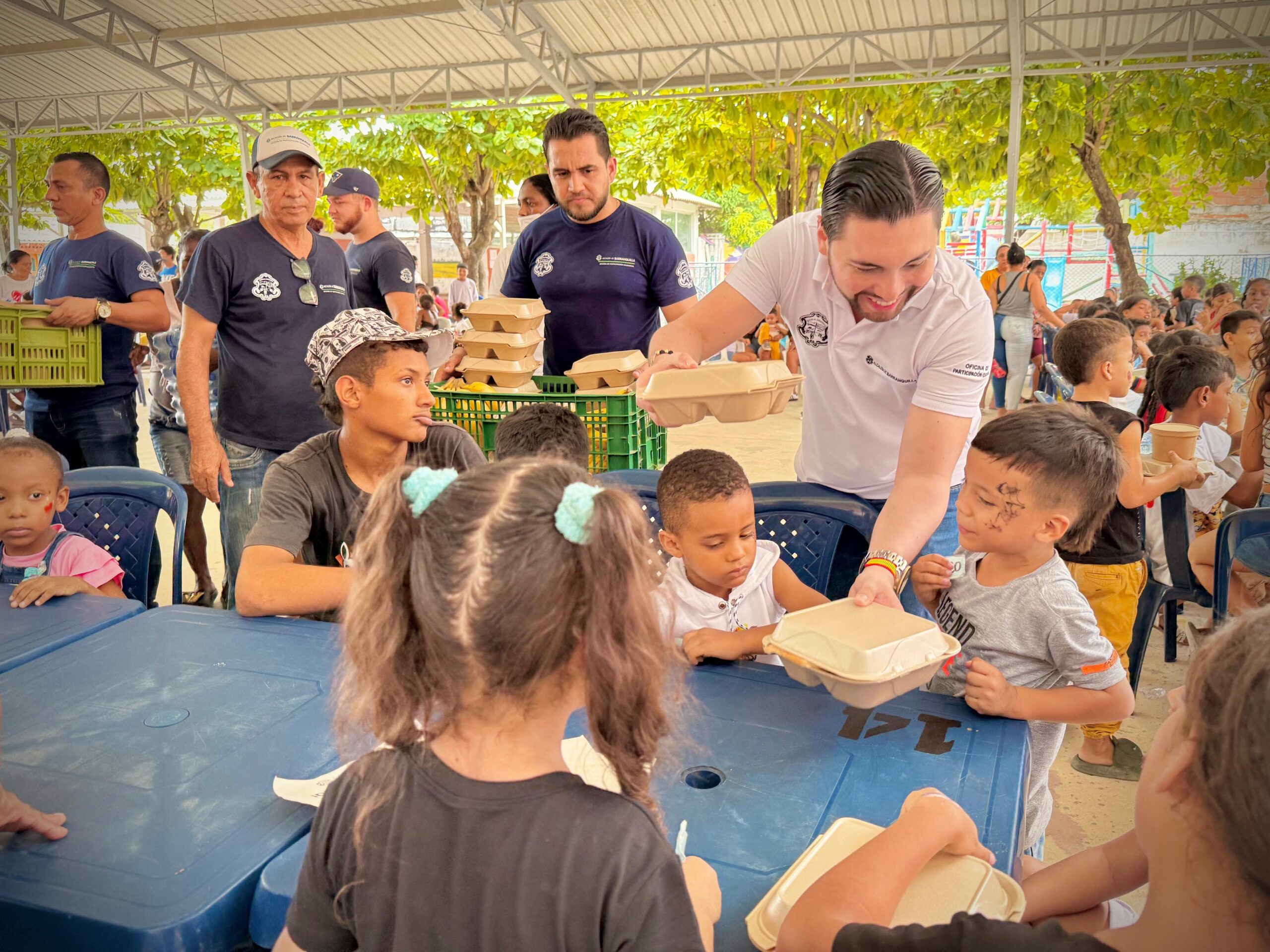 El jefe de la Oficina de la Oficina de Participación ciudadana colabora en la entrega de desayunos a niños del barrio La Paz como parte de una jornada comunitaria