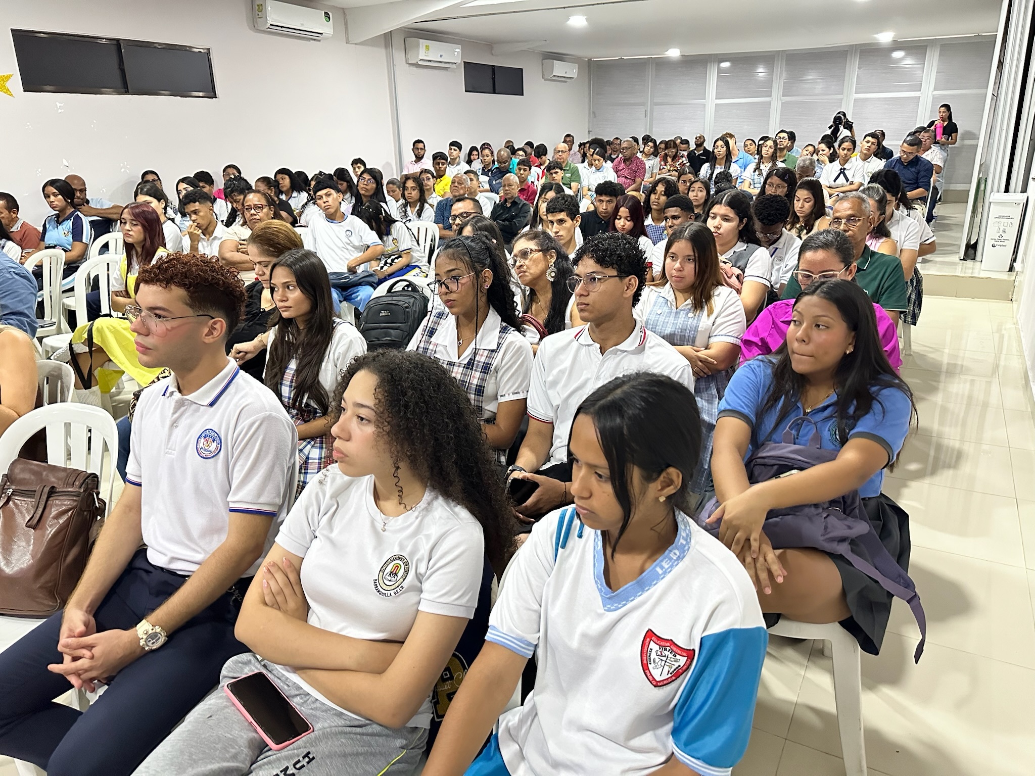Grupo de jóvenes sentados en un auditorio