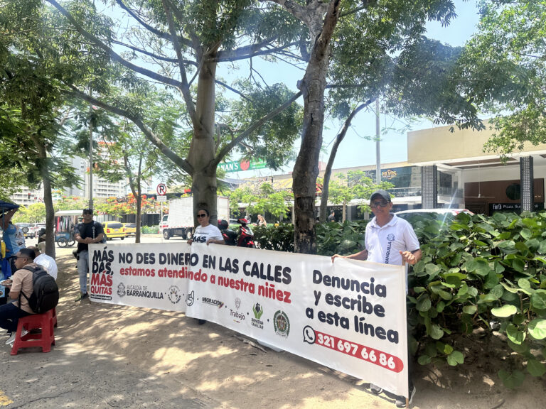 Funcionarios sostienen una pancarta con el mensaje: “No des dinero en las calles, estamos atendiendo a nuestra niñez”, como parte de la campaña “Más das, más quitas”.