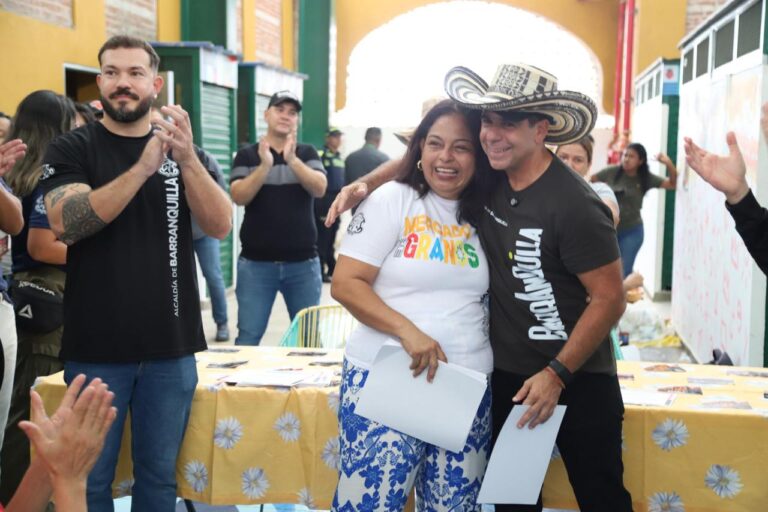 El alcalde Alejandro Char abraza a mujer del Mercado Granos al entregarle un reconocimiento.