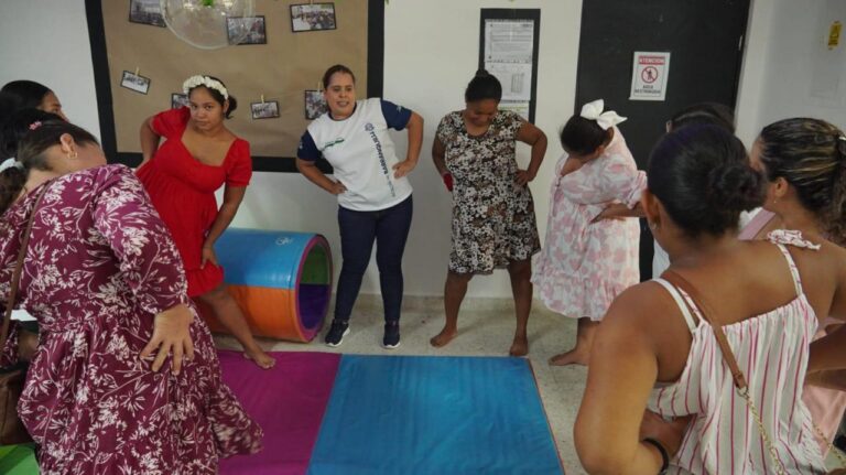 Mujeres embarazadas realizan ejercicios de estiramiento guiadas por funcionaria del programa de Primera Infancia.