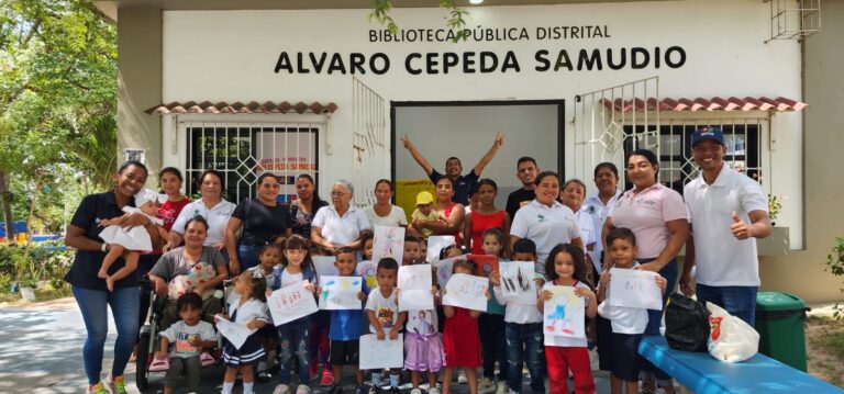 Grupo de personas posando para una foto frente a la Biblioteca Distrital Pública Álvaro Cepeda Samudio.