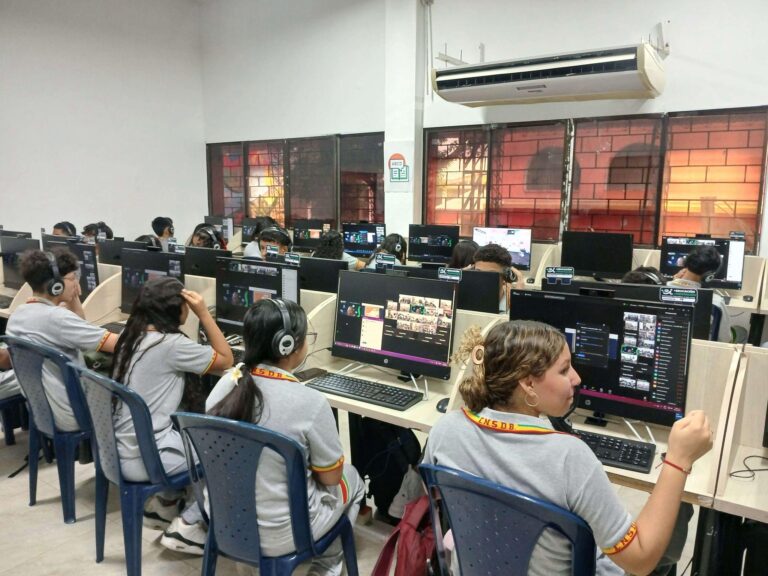 Alumnos frente a computadores en colegio