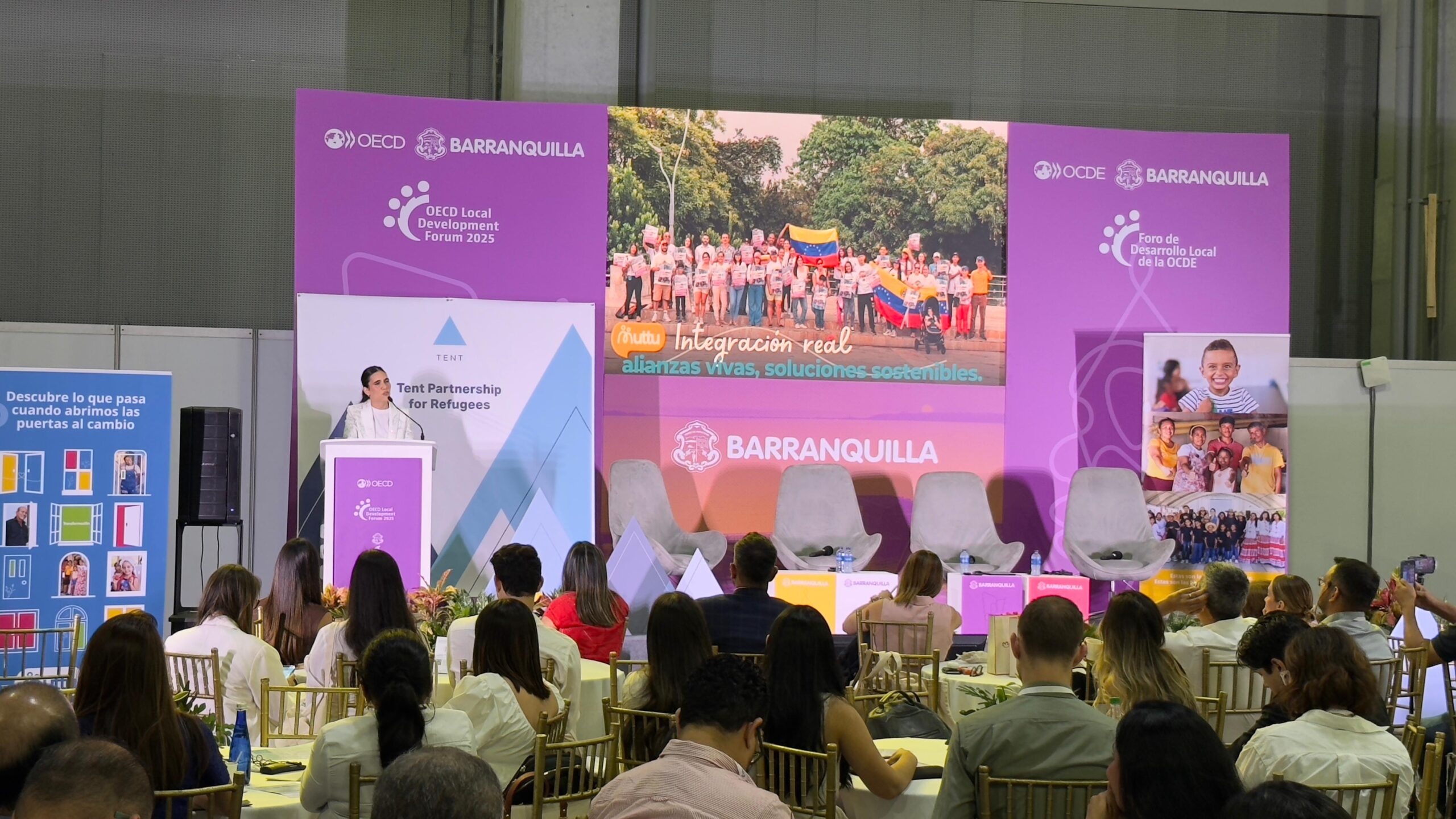 Ponente expone ante participantes sentados en mesas durante Foro Local  de Desarrollo Local en Barranquilla.